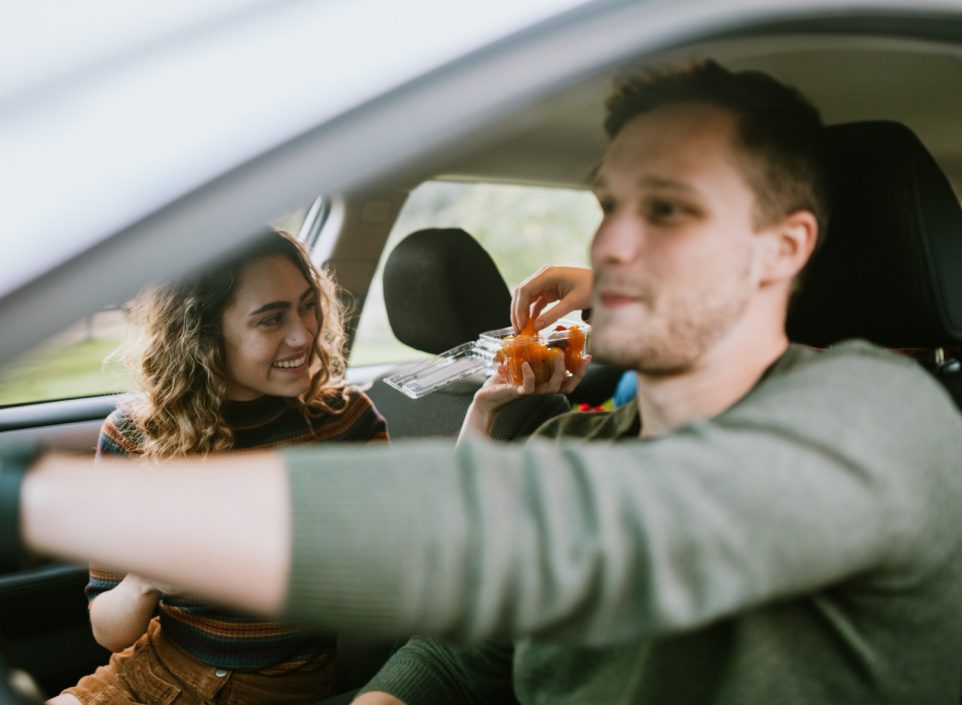 Woman sharing snacks with car passengers