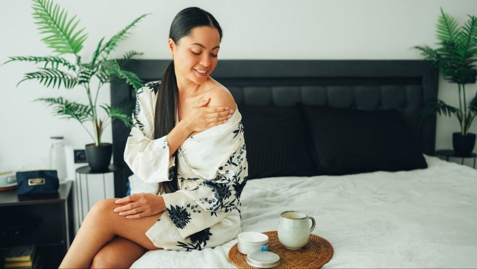 Woman at home using shea butter body cream