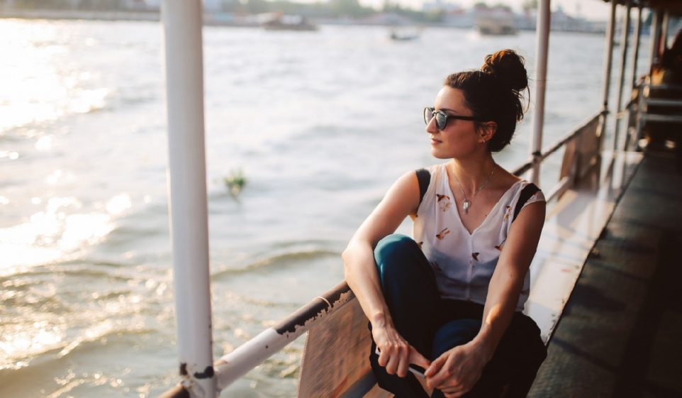 Young tourist woman riding on the Bangkok ferry boat