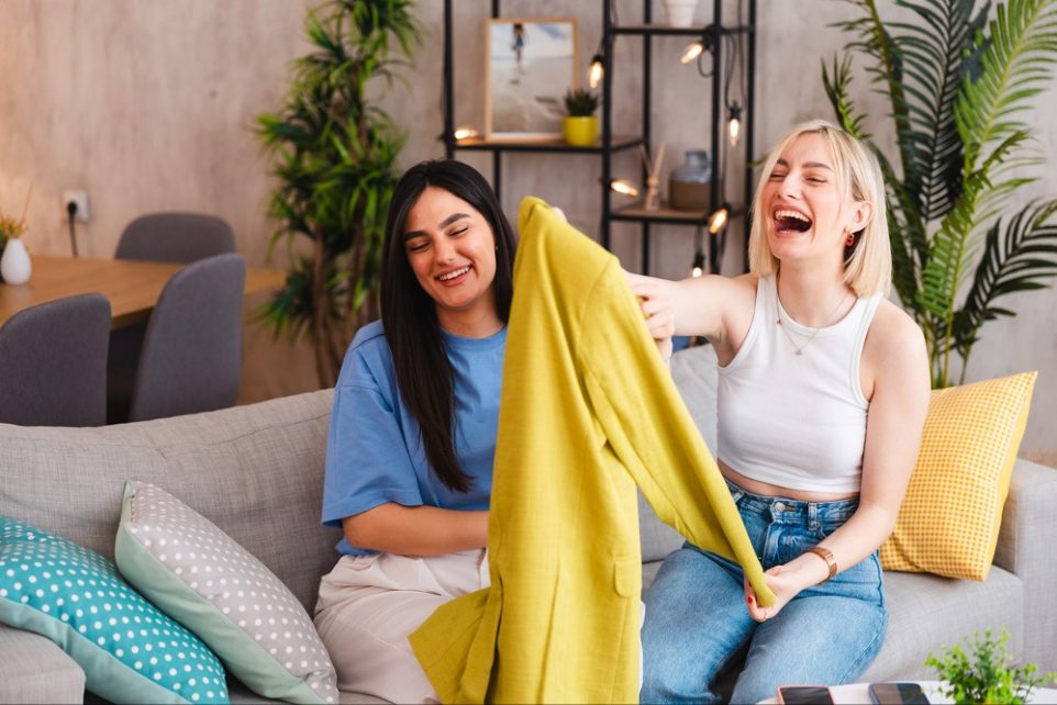 Two smiling young women trying on the clothes they bought online.